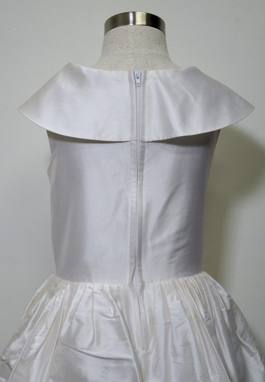 one of a kind satin communion dress Expressions Boutique NY, ruched satin communion gown, white pearl detail first communion dress, boutique communion wear Long Island, elegant satin ball gown for girls, special occasion dress Woodbury NY