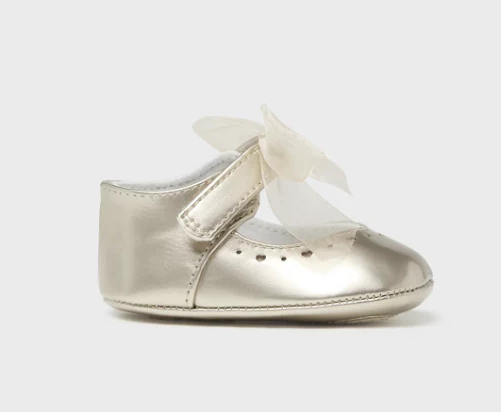 Metallic baby shoe with a bow on a white background