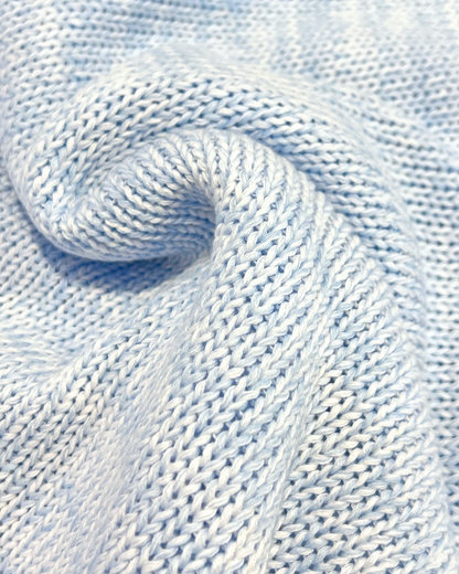 Close-up of light blue knitted fabric with a textured pattern.