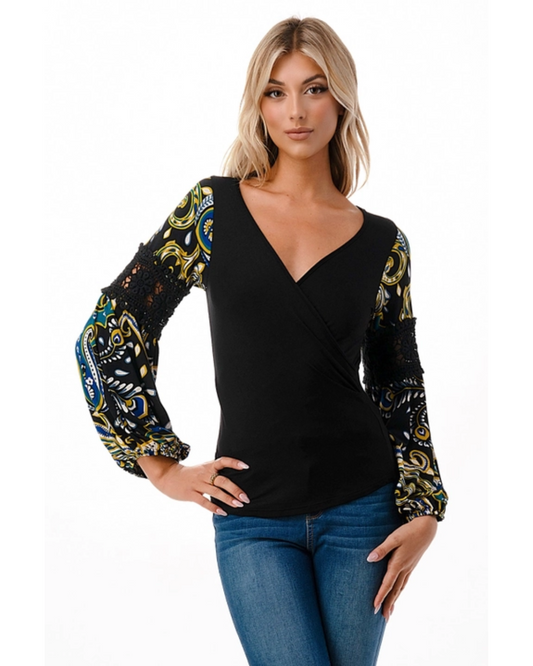 Woman wearing a black top with patterned sleeves on a white background
